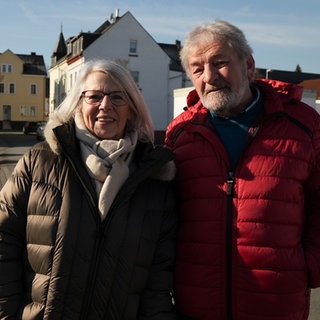 ältere Frau mit grauen Haaren mit ihrem Mann in roter Daunenjacke