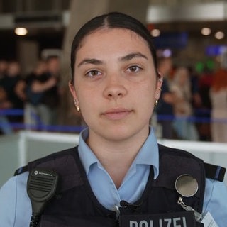 Junge Frau in Polizeiuniform schaut in die Kamera