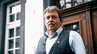 Älter Mann steht in einem Türrahmen