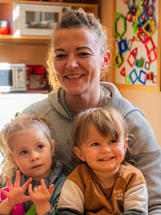 Frau mit zwei Kindern im Spielzimmer