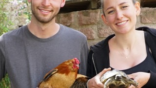 Ein junges heteropaar mit Tieren in der Hand