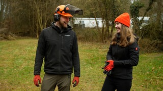 Pärchen steht auf Wiese und lacht sich an