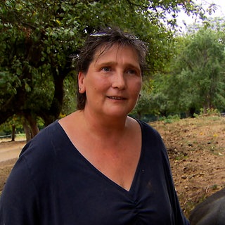 Eine Frau steht auf einer Wiese