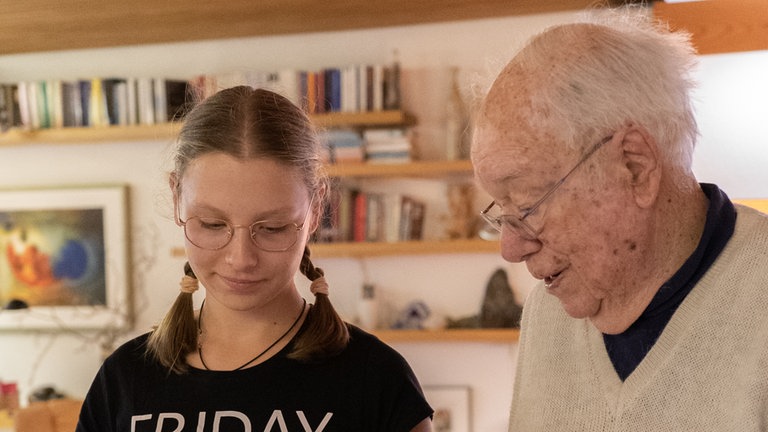 Georg und Laura schauen gemeinsam in ein Kinderbuch