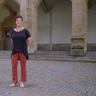 Frau steht vor Schule