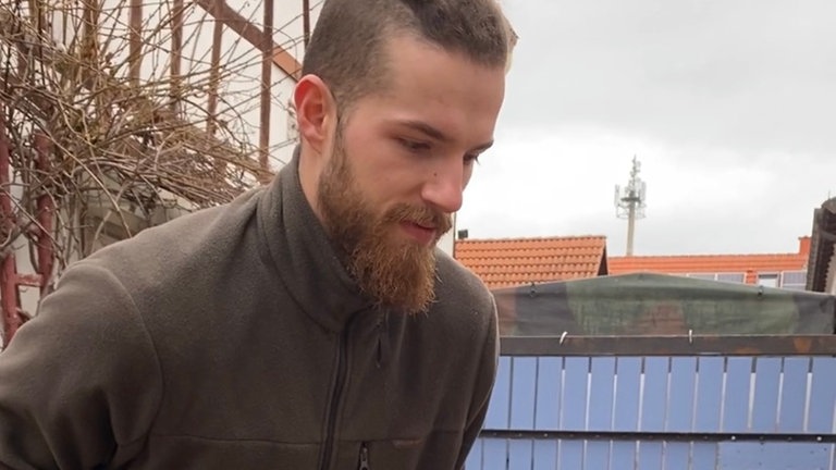  Junger Mann der draußen im Hof steht 