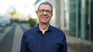 Mann vor unscharfem Hintergrund