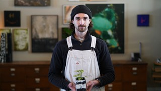 Junger Mann mit weißer Latzhose