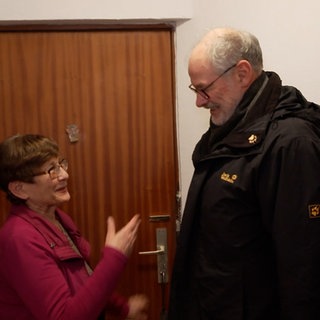 Ein Mitarbeiter vom Verein „Alt-Arm-Allein“ besucht eine ältere Frau, um ehrenamtlich Handwerksarbeiten durchzuführen.