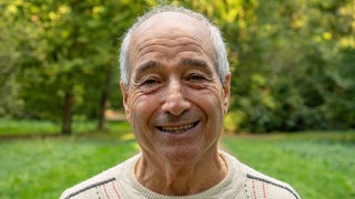 Ein älterer Mann lacht in die Kamera. Mit gerade mal 16 Jahren verlässt Luigi sein italienisches Dorf und kommt als Gastarbeiter nach Deutschland.