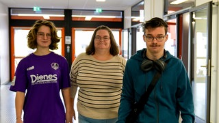 Eine Frau und zwei Jugendliche schauen in die Kamera. Tanja Zeitz und ihre Kinder mussten nach einem Brand aus ihrem Haus ausziehen.