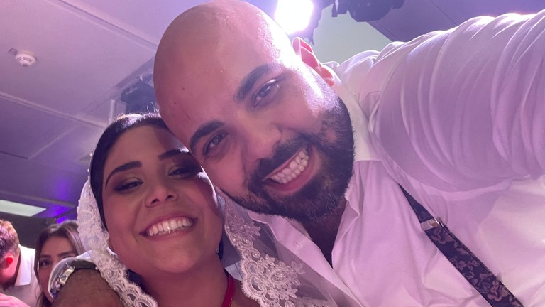 Junger Mann umarmt die Braut und macht ein Selfie.