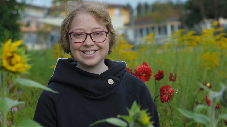 Junge Frau in einem Blumengarten
