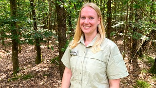 Junge Frau in Forstkleidung im Wald