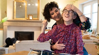 Mutter mit ihrer behinderten Tochter, die im Rollstuhl sitzt