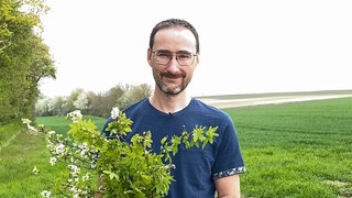 Junger Mann mit Blumenstrauß