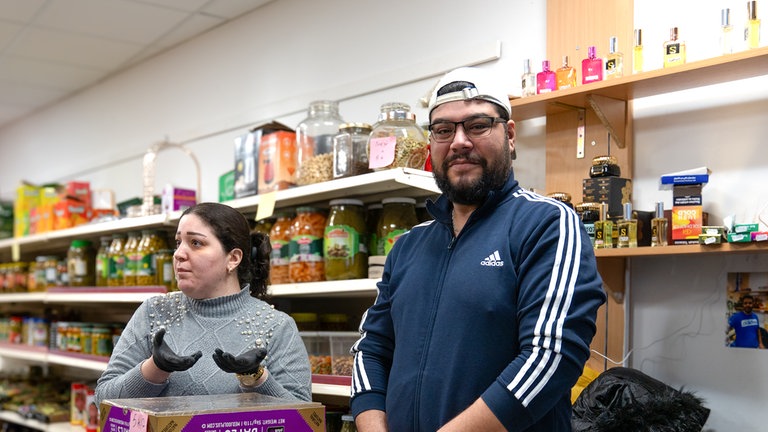 Der Mann schaut in die Kamera und die Frau spricht mit dem Reporter.