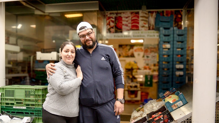 Ein Mann und eine Frau im Bild, sie halten sich im Arm.