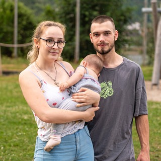 Junge Familie mit ihrer Tochter auf dem Arm im freien