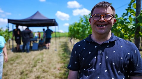 Junger Mann mit Down-Syndrom im Weinberg
