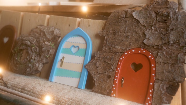 Zwei selbstgebaute Wichteltüren mit einem Holzstück.