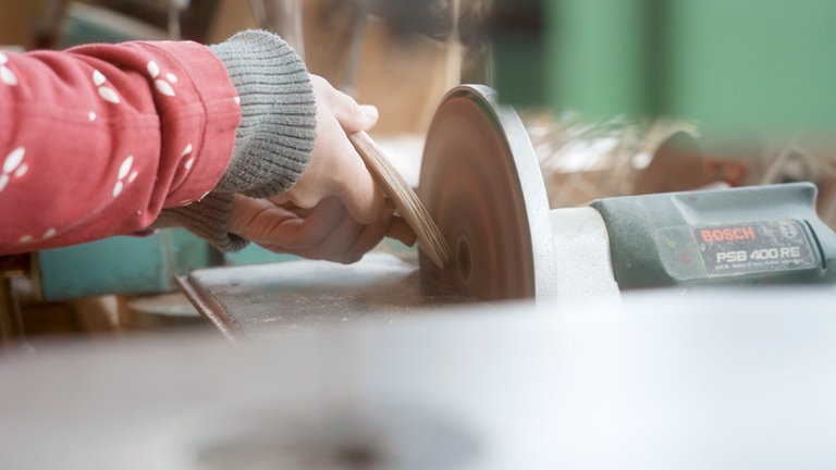 Kreissäge und Wichteltür, die geschliffen wird.