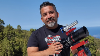 Mann auf Berg mit Kamera auf Stativ zum Sternefotografieren