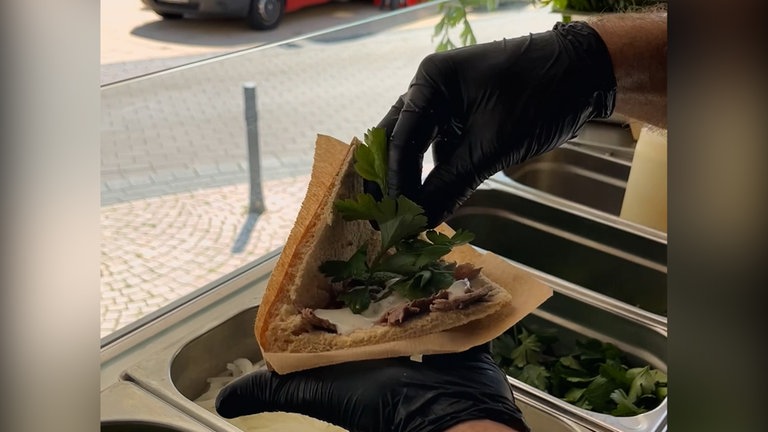 Ein Kebab Döner wird mit Zutaten gefüllt.