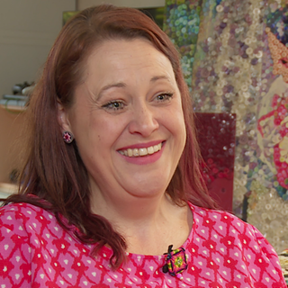 Junge Frau in Rosa kleid in ihrem Laden für Knöpfe