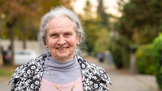 Frau mit grauen Haaren lächelt in die Kamera