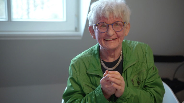 Ältere Frau die goldig lächelt.