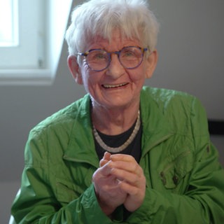 Ältere Frau die goldig lächelt.