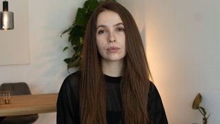 Eine junge Frau mit langen Haaren schaut in die Kamera. Shannon hat ihre Mutter an Krebs verloren. In ihrem Podcast "Mütter sterben nicht" spricht sie über den Verlust.