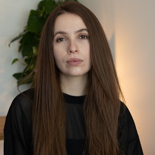 Eine junge Frau mit langen Haaren schaut in die Kamera. Shannon hat ihre Mutter an Krebs verloren. In ihrem Podcast "Mütter sterben nicht" spricht sie über den Verlust.