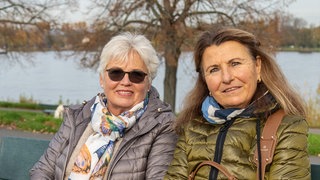 Zwei Damen auf einer Bank mit dem Rhein im Hintergrund