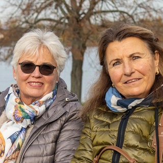 Zwei Damen auf einer Bank mit dem Rhein im Hintergrund