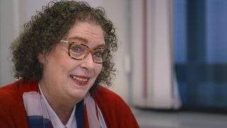 Proträt Frau mit Brille und lockigem Haar