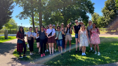 Gruppenfoto: 15 Frauen, die bei Women Walk and Talk zusammen spaziergehen, stehen zusammen und lächeln in die Kamera.