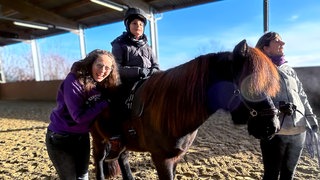 Nathalie hilft ihrem kleinen Patienten Haris durch eine Pferdetherapie mit Pferd Helgi. 