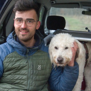 Wiedersehen im Welzheimer Wald: Hundebesitzer Hannes sitzt glücklich mit seinem wiedergefundenen Golden Doodle Benno im Auto.  