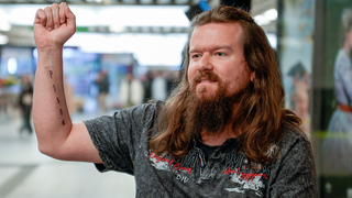 Philipp ist in einer Unterführung und zeigt ein Tattoo auf seinem Unterarm. Untereinander stehen die Buchstaben PINUM, die für seine fünf Lebensziele stehen. 