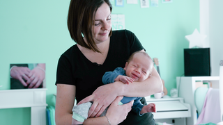 Mütterpflegerin Andrea hält ein Baby auf dem Arm.