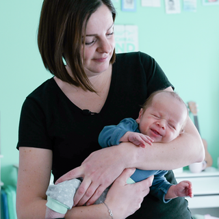 Mütterpflegerin Andrea hält ein Baby auf dem Arm.