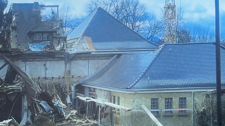 Halb eingestürztes Dach, Balken und andere Materialien ragen über den Dachboden hervor. Zustand des Gebäudes, vor der Sanierung. 