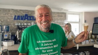 Mann im grünen T-Shirt mit Eis in der Hand.