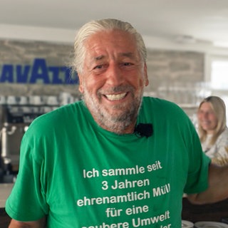 Mann im grünen T-Shirt mit Eis in der Hand.