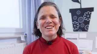 Cristina ist zufrieden mit ihrem Beruf als MTU in der Brustkrebsfrüherkennung und grinst in die Kamera.