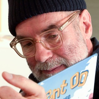 Ex-Gastronom Frieder ist heute Erzieher. Er liest den Kindern eine Geschichte aus einem Buch vor.