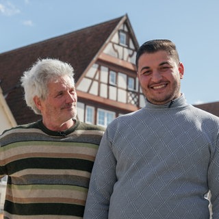 Ralf und Muath stehen nebeneinander auf dem Nürtinger Schillerplatz und schauen in die Kamera. Über die letzten drei Jahre sind die beiden sehr gute Freunde geworden.