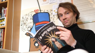 Porträt Junger Mann hat einen Comic in der Hand